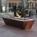 A long linear copper gas fire pit lit at dusk