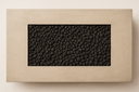 Overhead top-down view of the Kenton fire table burner filled with black lava rock framed by natural concrete