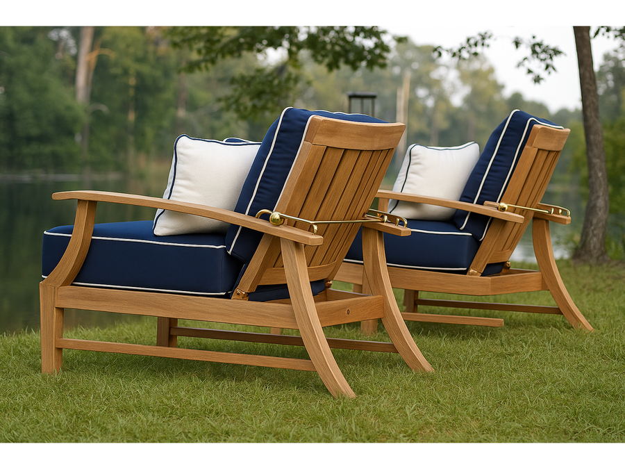 Two Summer Classics Croquet teak recliners with navy cushions and brass reclining hardware, beside a lake