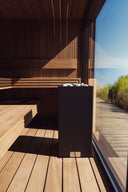 Dark wood sauna interior with a large window facing a deck