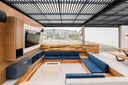 Sunken outdoor lounge with a TV wall under a modern louvered pergola