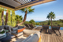 Aero rotating louvered roof above an outdoor lounge