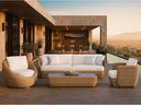 Jensen Velo outdoor lounge set with woven Solara fiber sofa and cement-top coffee table on a terrace at sunset